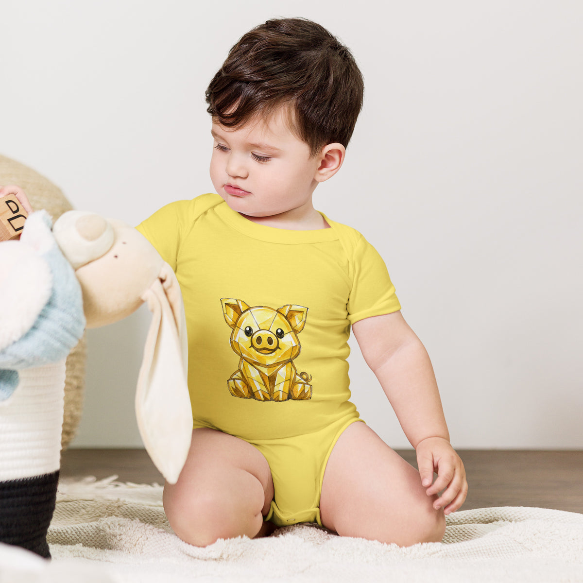 Baby bodysuit with a golden piggy print, worn by a baby