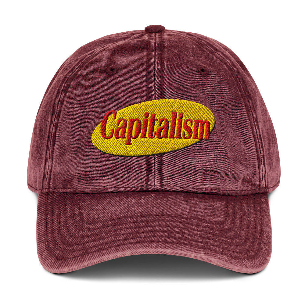 "Capitalism" in retro sitcom-style lettering on a vintage washed cotton twill cap