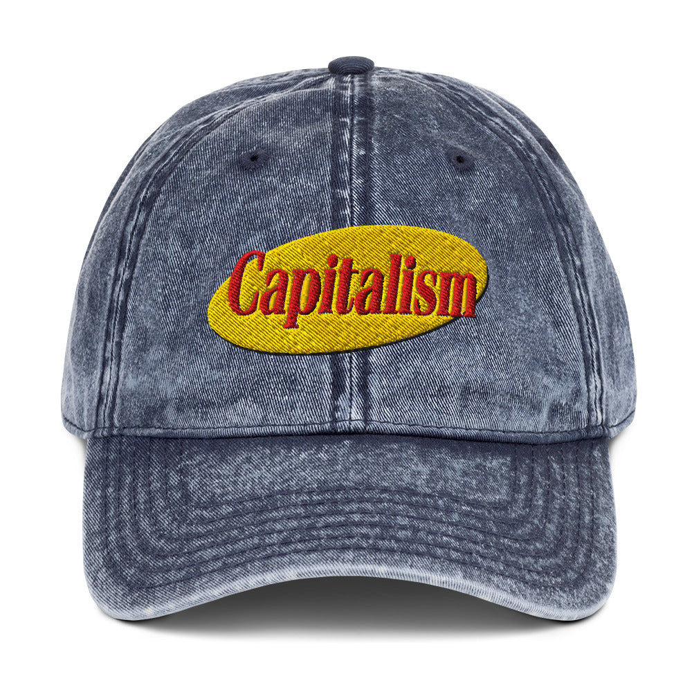 "Capitalism" in retro sitcom-style lettering on a vintage washed cotton twill cap