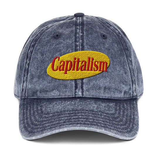 "Capitalism" in retro sitcom-style lettering on a vintage washed cotton twill cap
